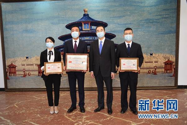 中国驻苏丹大使马新民（中）向出席会议的中国第35批援苏医疗队队长郭亚东及队员颁发苏丹联邦卫生部制作的荣誉证书。（马意翀摄）