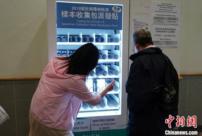 资料图：有市民在香港西湾河普通科门诊诊所的检测样本收集包“自动派发机”上自助领取样本包。中新社记者张炜摄