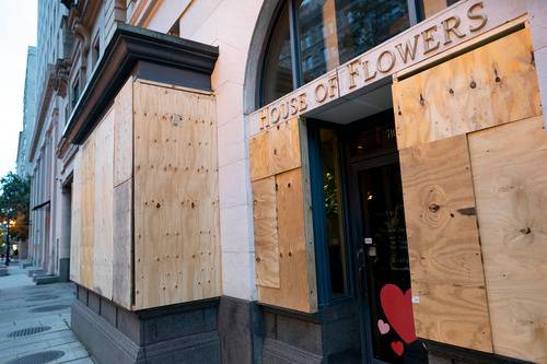 美国华盛顿，白宫附近的一家花店用木板加固了门窗。图源：新华社