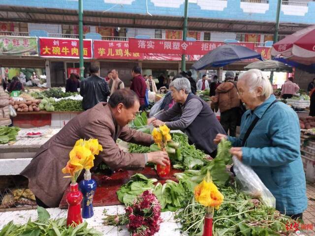 ↑王美成摆的鲜花菜摊。