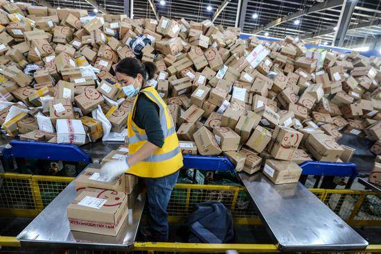 2020年11月11日，江苏淮安，市邮政速递物流公司的工作人员正在分发快件。视觉中国图
