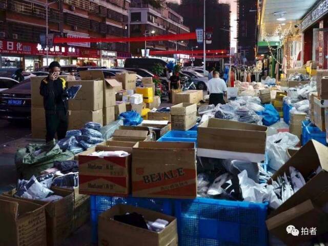 ▲晚8点，江北下朱村的商户门前堆满了各种货品。