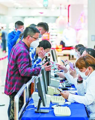消费者在上海一家商场的消费券服务台前排队办理业务。新华社发