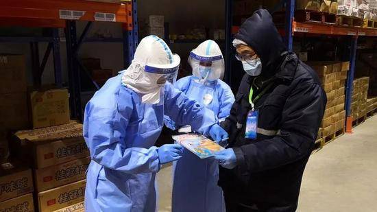 △11月16日，采样员在上海口岸冷库内对原料外包装进行核酸采样。陈玺撼摄