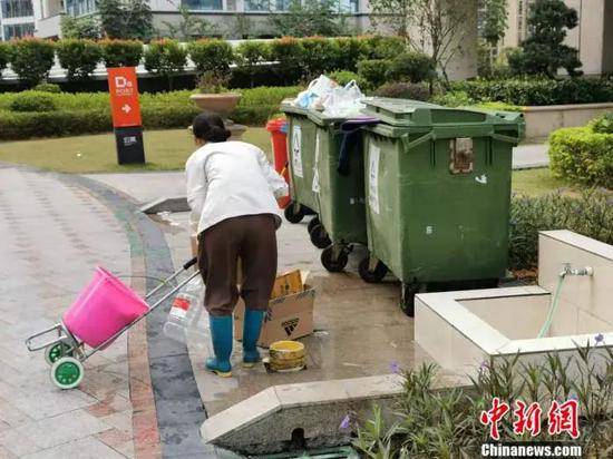 深圳一居民区附近，有人正在捡拾废弃的快递盒。受访者供图
