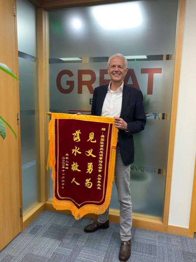 史云森和他收到的锦旗。英国驻重庆总领事馆供图