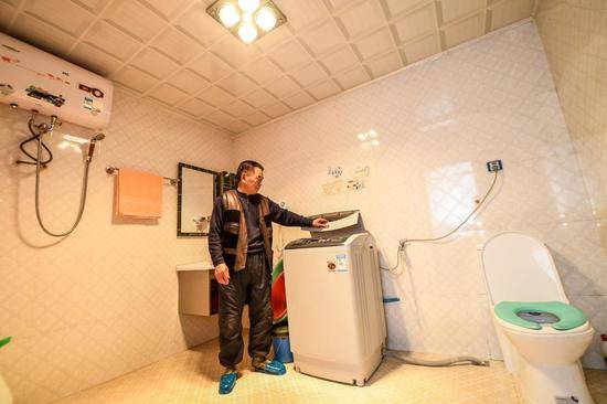  2017年1月24日，吉林延边光东村村民全得成在自家卫生间内使用洗衣机。