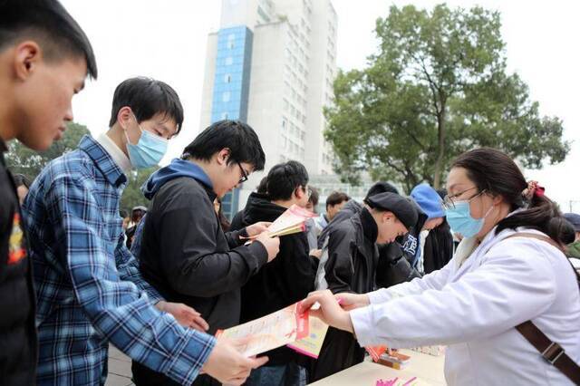 △11月30日重庆医务人员给大学生宣传艾滋病科普知识图源：视觉中国