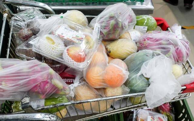 11月14日，物美超市惠新店，一辆购物车里放满了用塑料连卷袋包装的果蔬。摄影/新京报记者李凯祥