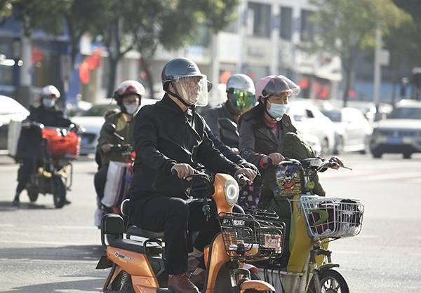 2020年10月9日，江苏省淮安市淮海北路与健康东路路口，电动车骑行者主动戴头盔出行。人民视觉资料图