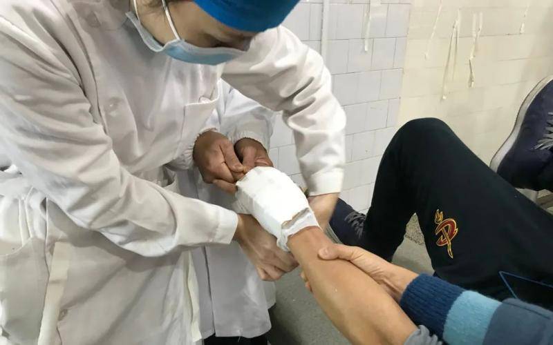 11月28日，社港医院手法正骨室，医护在为掌骨骨折患者包扎。新京报记者张惠兰摄