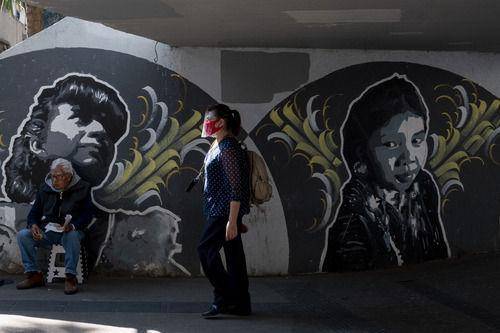 11月24日，在墨西哥首都墨西哥城，一名女子戴着口罩和面罩出行。新华社发（路易斯摄）