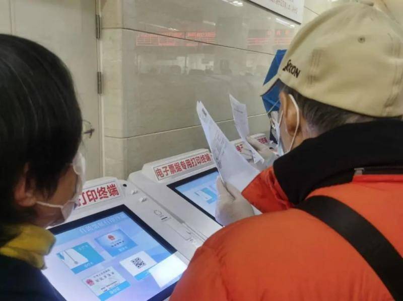 老年患者在第九人民医院请教志愿者打印电子票据。
