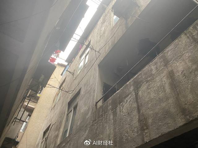 图说：张建新在联建集贸市场后面租了一间老私房，从下仰望，一线天。