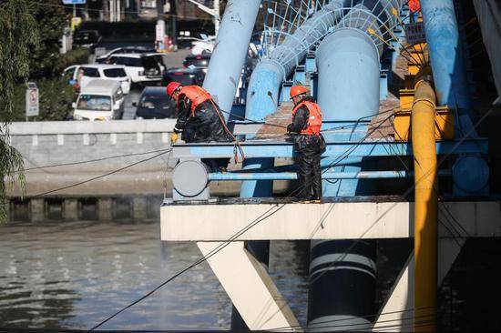 施工人员正在对跨越苏州河的共和新路桥进行刷漆和清理。