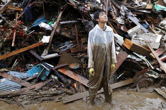 7月7日，日本九州等地区遭遇创纪录大雨，日本熊本县人吉市，居民在朋友家帮忙清理废墟。