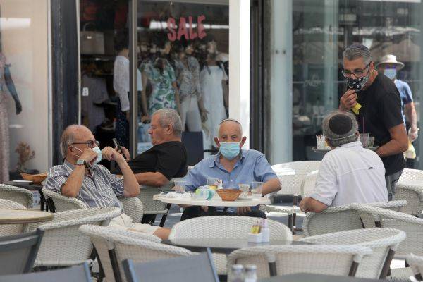这是9月14日在以色列城市内坦亚街头拍摄的戴口罩的民众。（新华社）