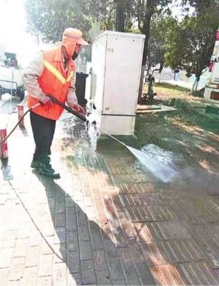 环卫工人对路面进行人工冲洗。东湖风景区市政维修管理处供图