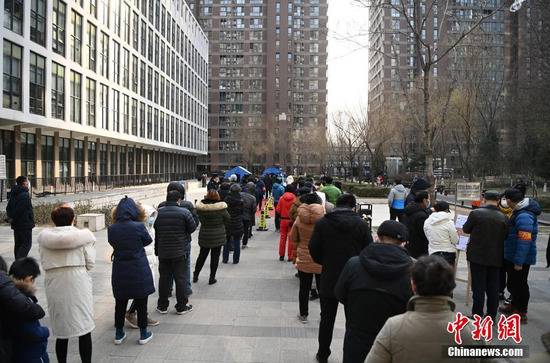 12月26日，根据新冠肺炎疫情防控要求，北京市朝阳区望京地区望京街道、东湖街道开展为期两天的社区全员核酸检测。图为居民在望京街道一处小区内的采样点排队等待核酸检测采样。中新社记者侯宇摄