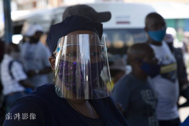 南非约翰内斯堡民众戴着面罩预防新冠肺炎，图自澎湃影像