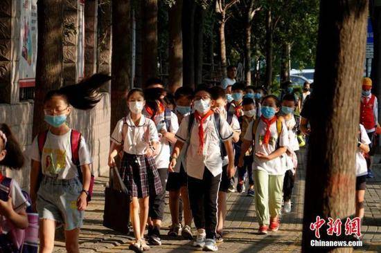 资料图：9月1日，河南郑州，长江东路小学迎来开学第一天，学生戴口罩有序进入校园。中新社记者王中举摄