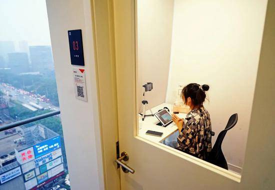 在武汉光谷某商圈写字楼內，培训中心老师在房间内进行线上教学。图片来源：视觉中国