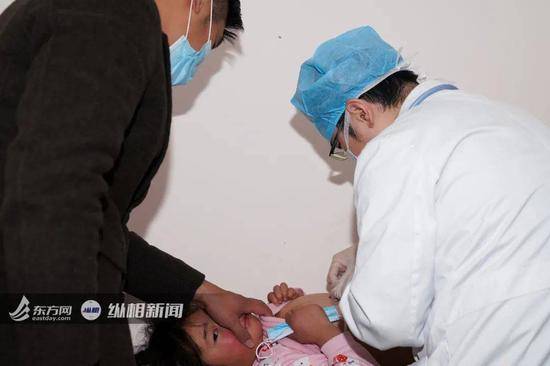 （复旦大学附属儿科医院，张惠锋正在给心脏手术后复查的患儿拆线。纵相新闻丁一涵/摄）