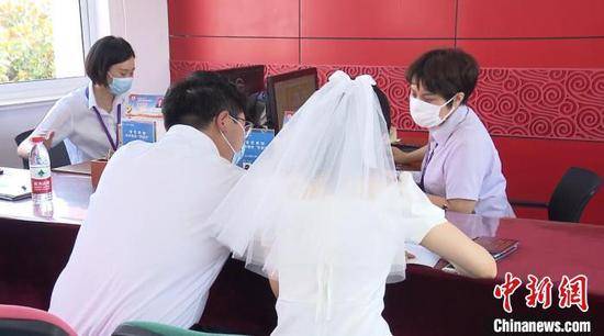 资料图：穿着婚纱登记结婚的新人杨季峰摄