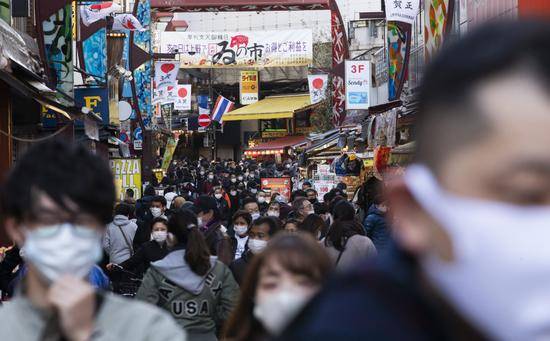 2020年12月31日，人们在日本东京一处商业街逛街。新华社图