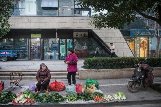 小区门口，郎建的便利店紧挨着快递驿站（陈中秋摄）