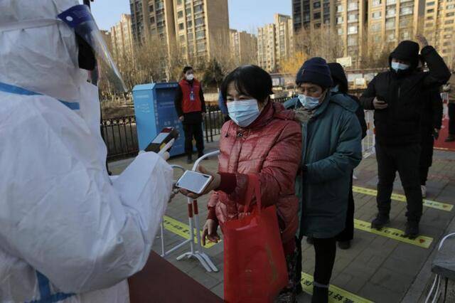 顺义区双丰街道香悦西区核酸采样点，居民排队出示预约二维码进行登记。新京报记者郑新洽摄