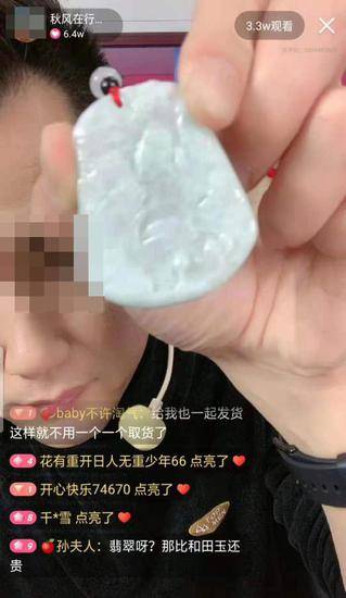 秋风在直播间叫卖劣质玉石，并在展示商品时进行“砍价表演”。视频截图