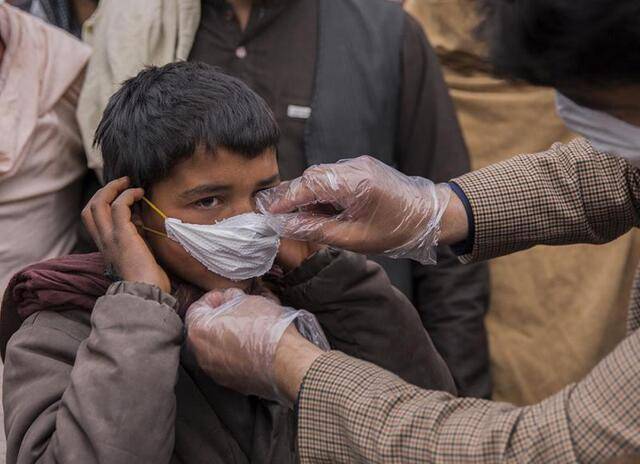 ↑2020年2月26日，在阿富汗赫拉特省，一名男子为当地民众分发简易口罩。阿富汗卫生部门2月24日报告，赫拉特省出现该国首个新冠确诊病例。新华社发（埃拉哈·萨赫勒摄）