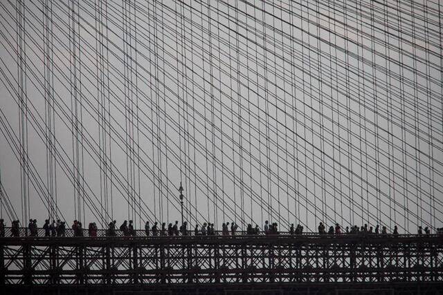 ↑2020年6月6日，抗议警察暴力执法导致乔治·弗洛伊德死亡的示威人群走过美国纽约布鲁克林大桥。新华社发（郭克摄）