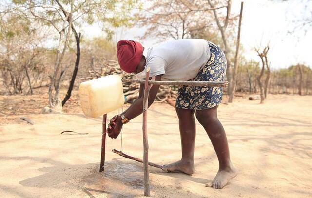 ↑2020年8月21日，在津巴布韦马尼卡兰省的古塔乌拉雷村，村民用“脚踏式洗手器”洗手，减少新冠病毒感染风险。新华社发（肖恩·朱萨摄）