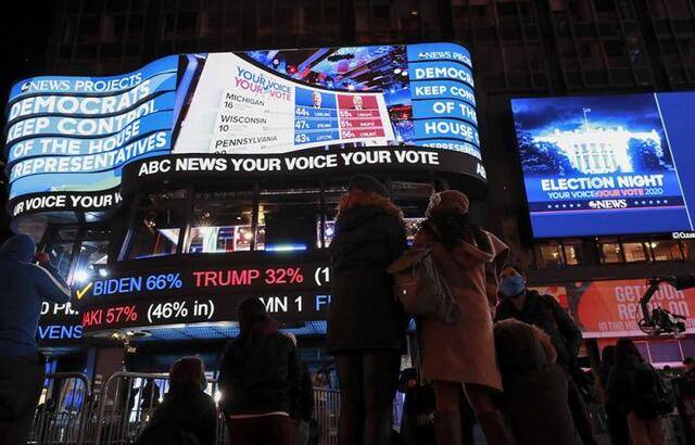 ↑2020年11月3日美国大选投票日当晚，人们在美国纽约时报广场观看实时计票结果。新华社记者王迎摄