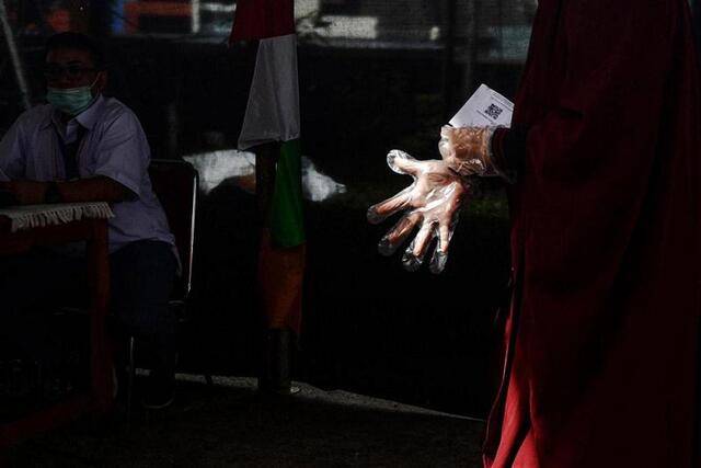 ↑2020年12月9日，在印度尼西亚的南唐格朗，选民戴上手套准备参加地方行政长官选举投票。新华社发（阿贡摄）
