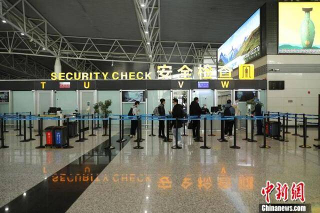 机场工作人员提醒旅客保持一米距离。毓秀斋摄