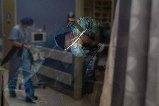△当地时间7日，加州一家医院的护士正在照顾她的新冠肺炎患者（图片来自美联社）