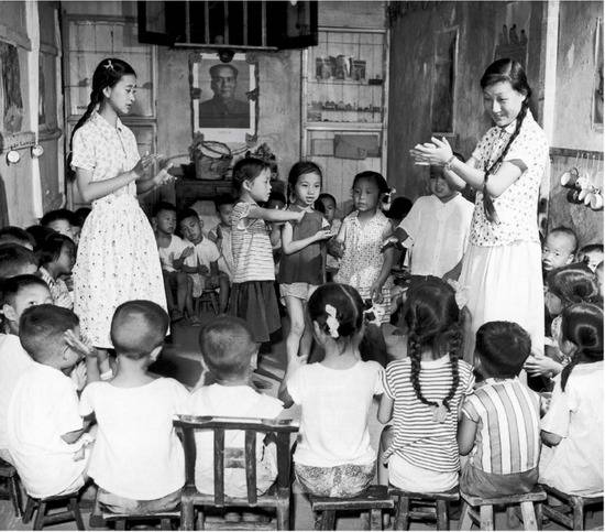 1958年，国内一幼儿园老师带孩子们做游戏（视觉中国供图）