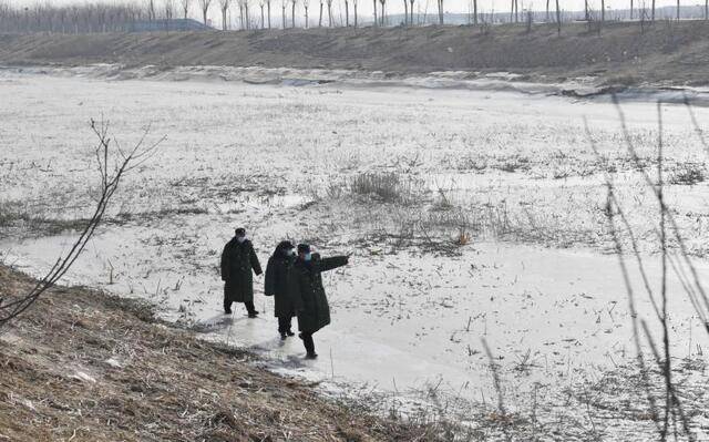 1月12日，礼贤镇综治办工作人员在冰冻的永定河河道内巡逻。新京报记者李木易摄