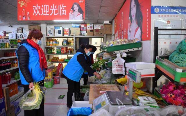 1月12日，大兴区榆垡镇求贤村，巾帼志愿者服务队队员在超市为居家隔离人员买菜。新京报记者李木易摄