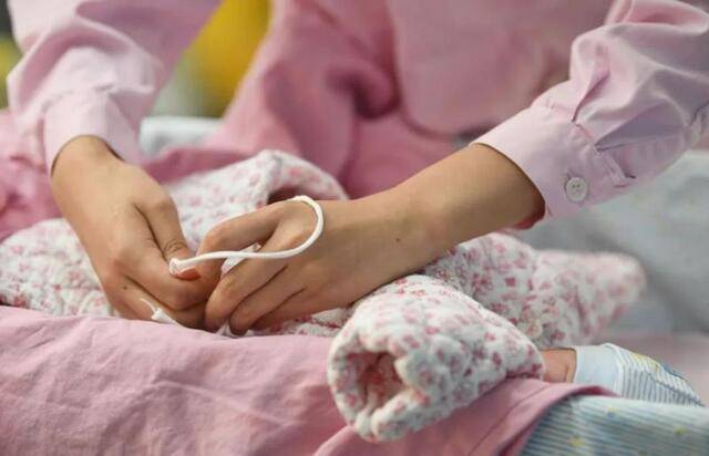 一名助产士在为刚出生的婴儿穿衣服 邓华 摄