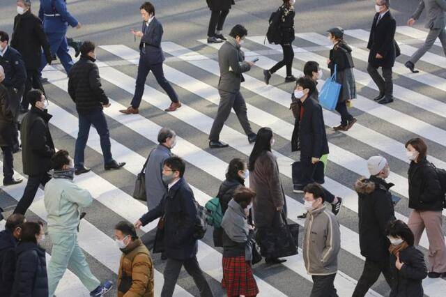 1月13日，佩戴口罩的行人走过日本东京的一处十字路口。新华社图