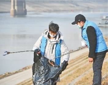 文昌植和孙子文杰在汉江边清理沿岸垃圾。记者詹松摄
