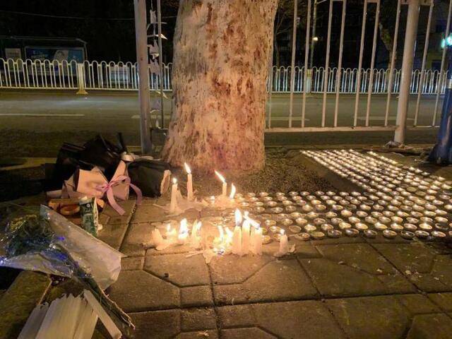 2021年1月23日，昆明五华区云南师范大学附属实验中学附近，有市民自发前来，在人行道边上点蜡烛献花，向遇难者致哀。|图：人民视觉