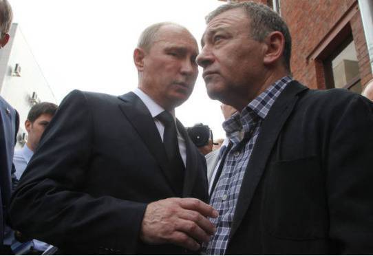 （图说：2013年8月9日，普京和罗滕贝格在圣彼得堡出席柔道教练拉赫林的葬礼。图/Getty Images）