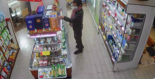 超市监控画面记录下了男子偷酒的行径