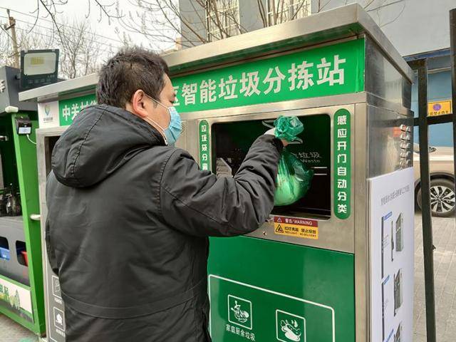 1月14日，中关村街道双榆树东里7号楼，社区居民使用“垃圾袋分离机器人”投放厨余垃圾。新京报记者浦峰摄