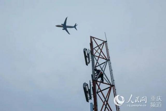 母科峰在导航台天线铁塔上巡查，一架飞机从他头顶飞过。邹乐摄